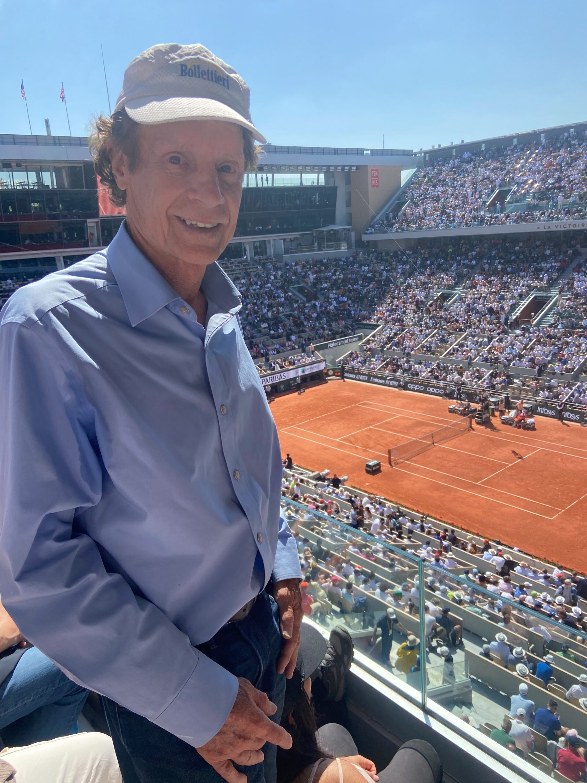 Marshall Hubsher at the French Open with a clay court in the background.